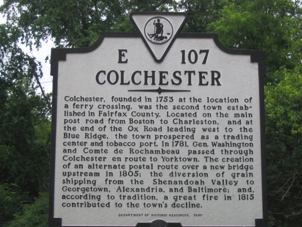 Image of Colchester roadside marker. The sign reads: Colchester, founded in 1753 at the location of a ferry crossing, was the second town established in Fairfax County. Located on the main post road from Boston to Charleston, and at the end of the Ox Road leading west to the Blue Ridge, the town prospered as a trading center and tobacco port. In 1781, Gen. Washington and Comte de Rochambeau passed through Colchester en route to Yorktown. The creation of an alternate postal route over a new bridge upstream in 1805; the diversion of grain shipping from the Shenandoah Valley to Georgetown, Alexandria, and Baltimore; and, according to tradition, a great fire in 1815 contributed to the town's decline.